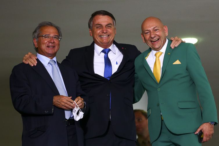 O empresário Luciano Hang, o presidente Jair Bolsonaro e o ministro da Economia, Paulo Guedes, durante o lançamento do programa Voo Simples, no Palácio do Planalto.